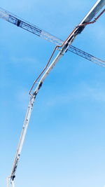 Low angle view of crane against blue sky