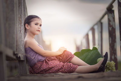 Young woman sitting on railing