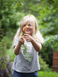 Smiling girl holding carrot