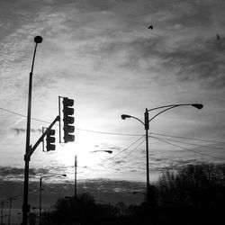 Lamp post against cloudy sky