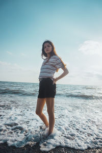 Full length of teenage girl standing on beach