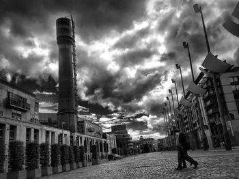 Buildings in city against cloudy sky