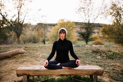 Full length of man sitting on wooden bench