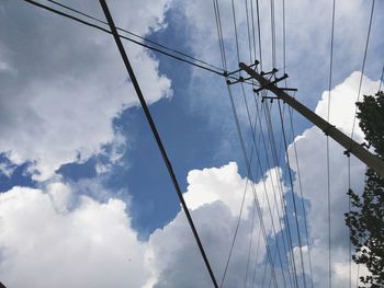 Low angle view of silhouette electricity pylon against sky