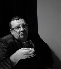 Thoughtful businessman holding wineglass