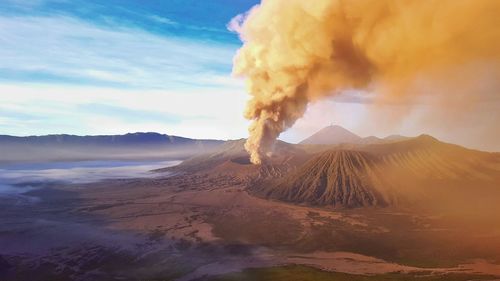 Smoke erupting from mt bromo against cloudy sky