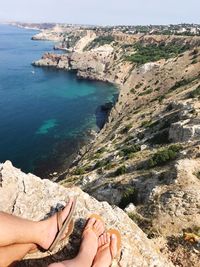 Low section of man relaxing on rock