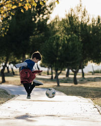 Happy kid jumping enjoying with soccer ball in nature. freedom and happiness concept