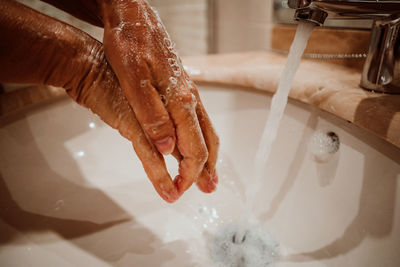 Close-up of human hand in bathroom