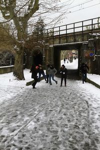 People walking on snow covered landscape during winter