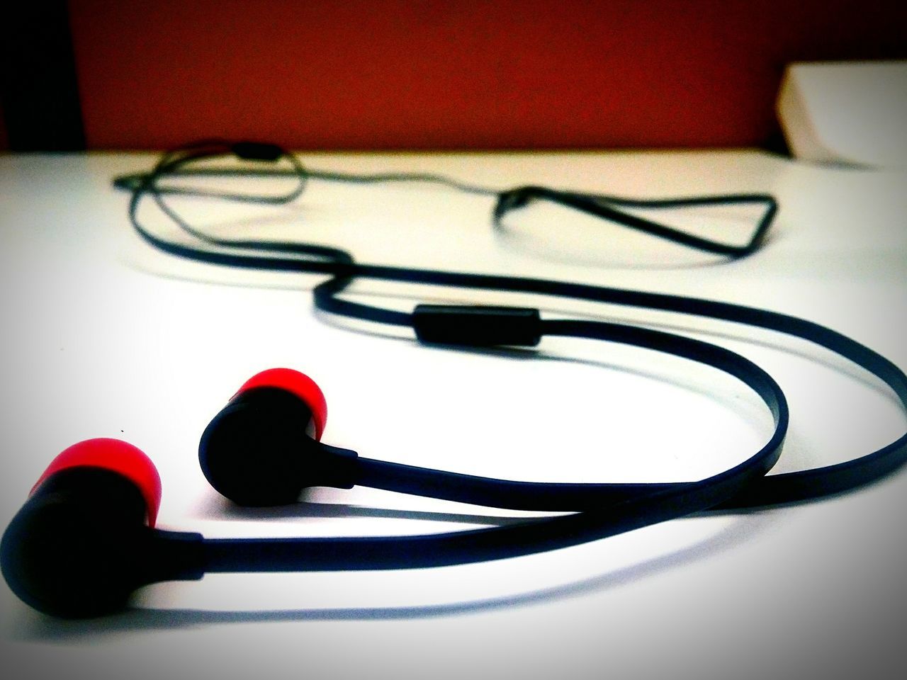 indoors, still life, close-up, table, red, single object, no people, man made object, high angle view, metal, connection, equipment, studio shot, ideas, focus on foreground, two objects, technology, selective focus, white color, hanging