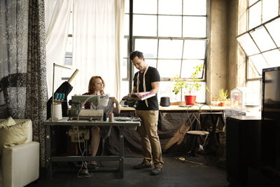 Fashion designers working against windows at workshop