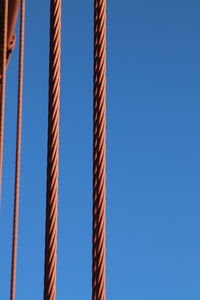 Low angle view of railing against clear blue sky