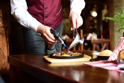 Midsection of man preparing food on table