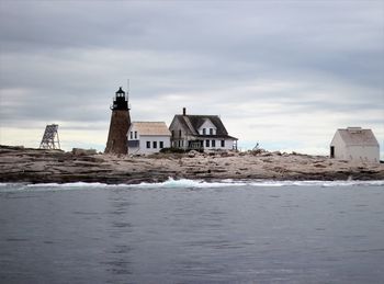 Buildings by sea against sky