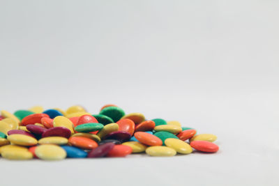 Close-up of multi colored candies against white background