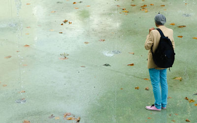 Rear view of woman standing against wall