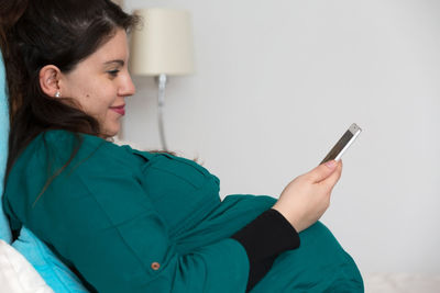 Side view of young woman using mobile phone