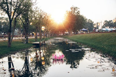 Scenic view of lake in park against sky during sunset