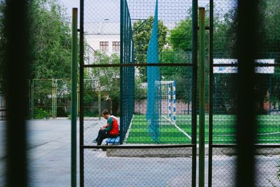 Man sitting by sitting by baseball court