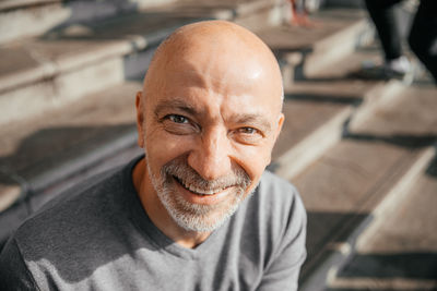 Senior man with a joyful smile sitting outdoors in urban area