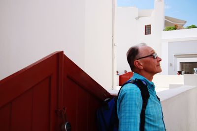 Side view of man standing against building