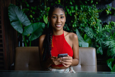 Portrait of smiling young woman using mobile phone