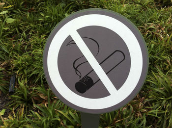 Close-up of no smoking sign against plants