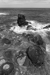 Scenic view of rocks on beach against sky