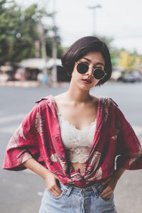 Portrait of sensuous woman wearing sunglasses while standing on road