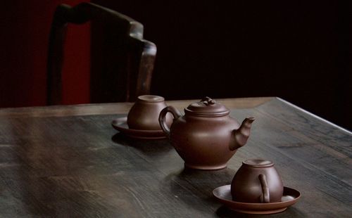 Cups with teapot on table
