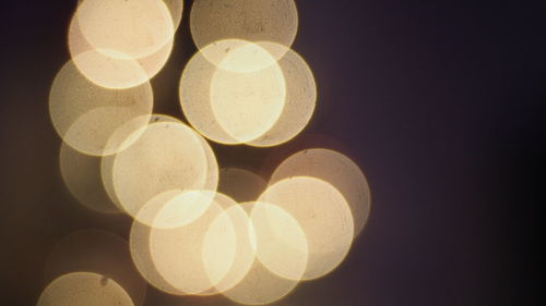 Close-up of illuminated lights against black background
