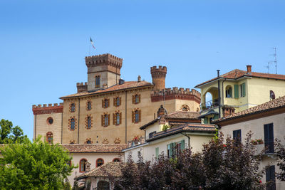 Low angle view of buildings against clear blue sky