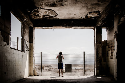 Rear view of a man standing against the sky