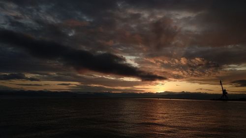 Scenic view of sea against dramatic sky during sunset