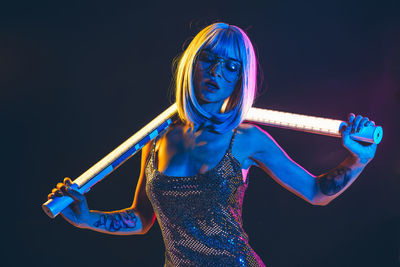 Woman wearing mask against black background