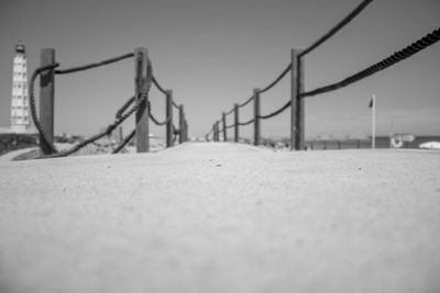 Surface level of sandy beach against clear sky