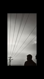 Silhouette of power lines against sky