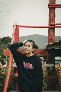 Portrait of girl standing against railing