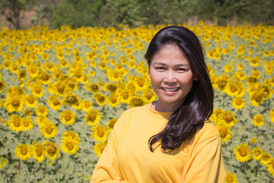 Portrait of smiling woman amidst flowering field