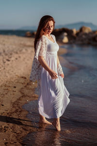 Full length of woman standing on beach