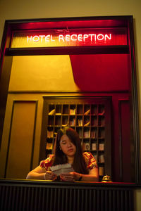 Lady opening mysterious letter at the hotel reception