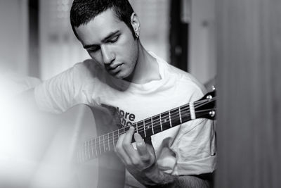 Man playing guitar at home