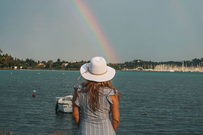 Rear view of a woman watching sea and rainbow