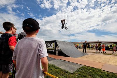 Rear view of people enjoying against sky