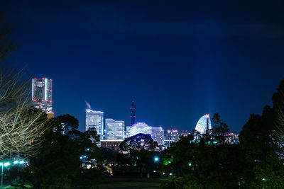 Illuminated cityscape against sky at night