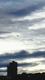 Silhouette of airplane flying in sky