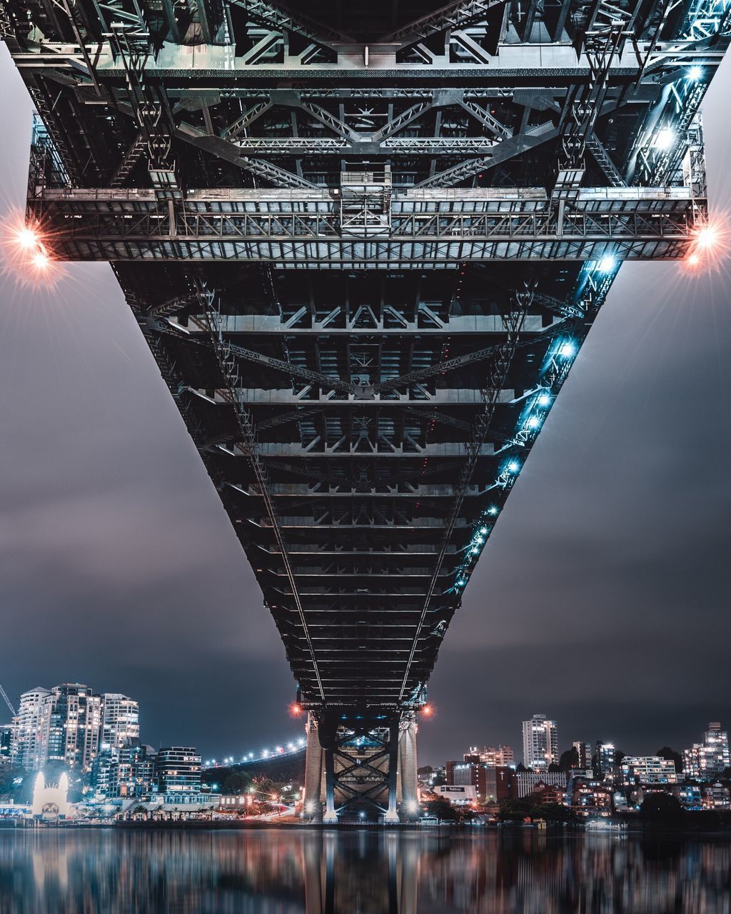 Underneath view of bridge in illuminated city at night