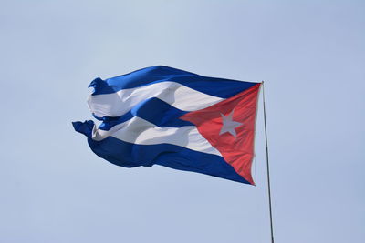 Low angle view of flag against clear blue sky