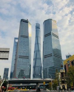 Low angle view of modern buildings against cloudy sky